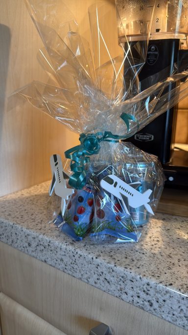 Geschenk mit bunten Eiern und dekorativen Fliegern in transparenter Verpackung.